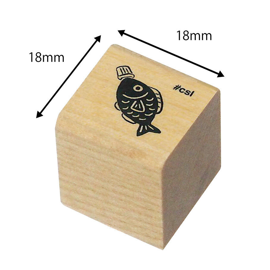 Wooden stamp block with fish design and measurements on a white background