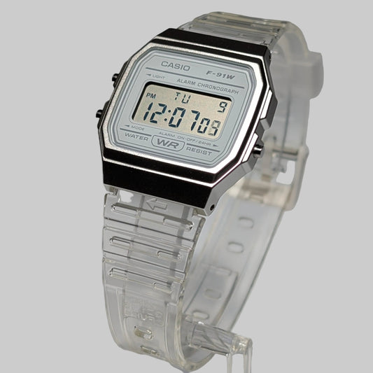 Digital watch with clear strap and Casio branding on a gray background