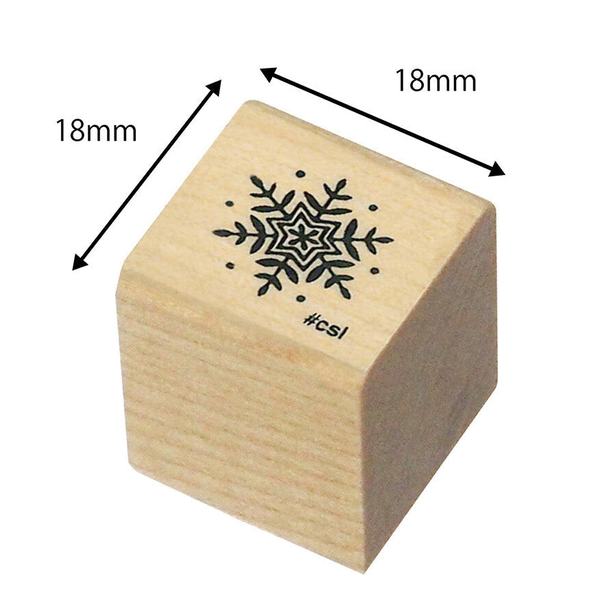 Wooden stamp with snowflake design and measurements on a white background