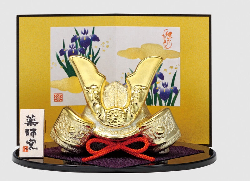 Japanese kabuto helmet in front of traditional artwork.