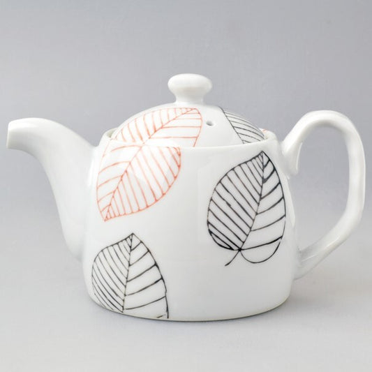 White teapot with leaf patterns on a gray background