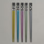 Set of five colorful chopsticks with floral patterns on a gray background