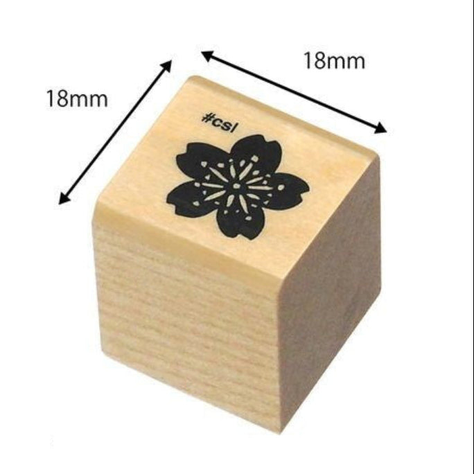 Wooden stamp with a cherry blossom design and measurements on a white background