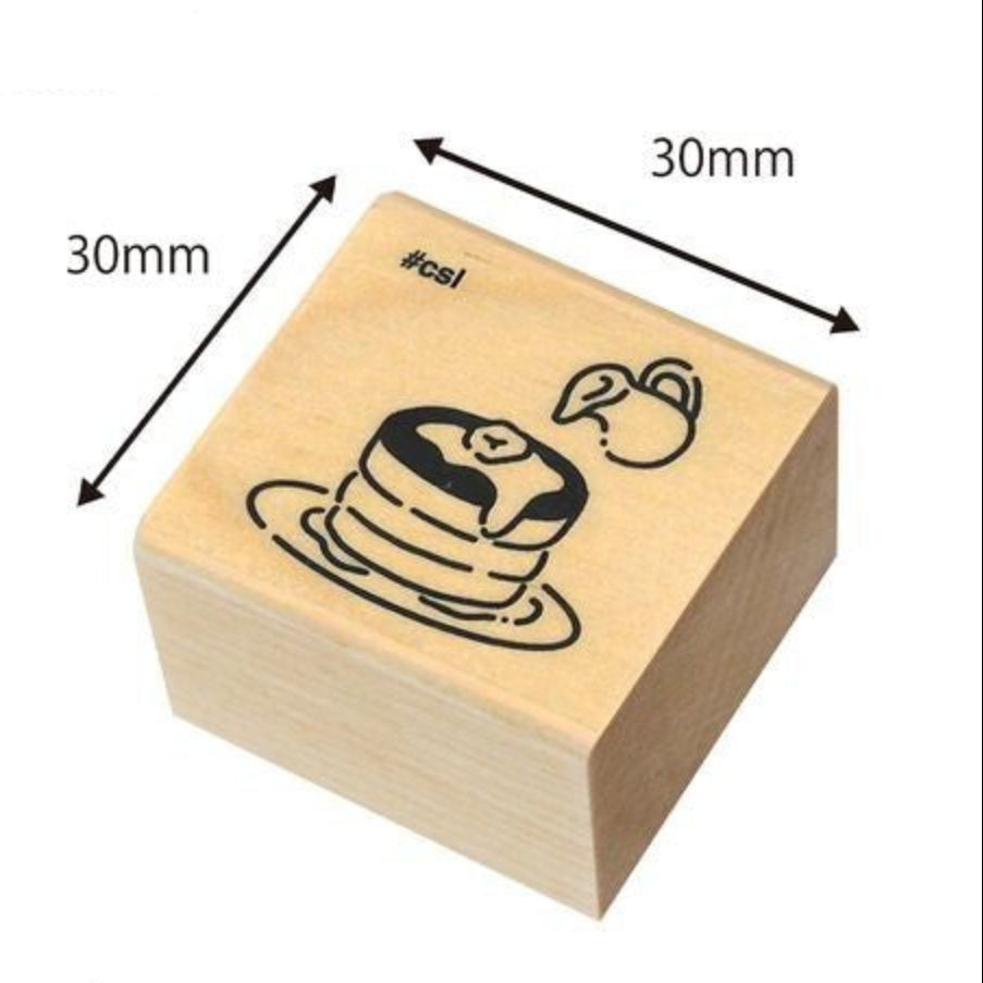 Wooden stamp block with a design of pancakes, dimensions indicated, on a white background.