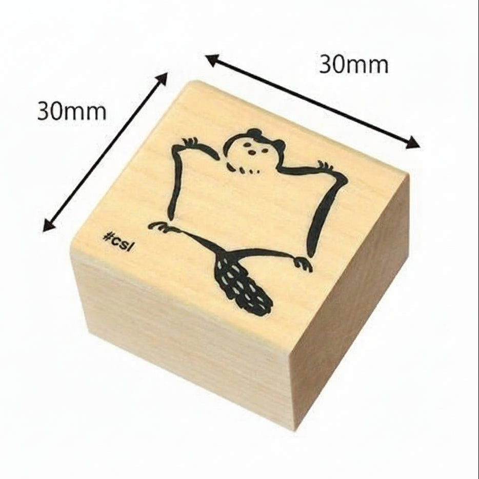Wooden stamp with a design of a flying squirrel, dimensions indicated, on a white background.
