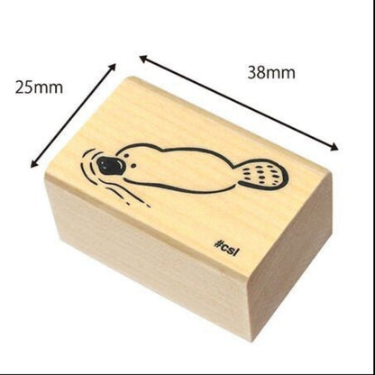 Wooden stamp block with a platypus design and dimensions labeled
