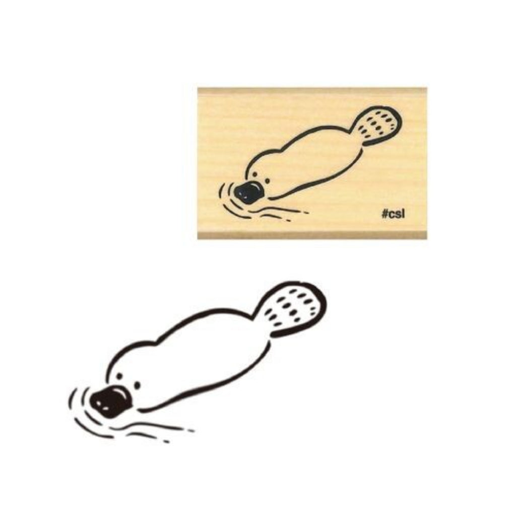 Wooden stamp with a stylized platypus design on a white background.