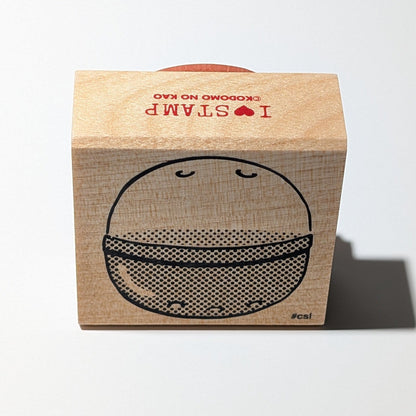 Wooden stamp with a design of a gachapon capsule on a white background