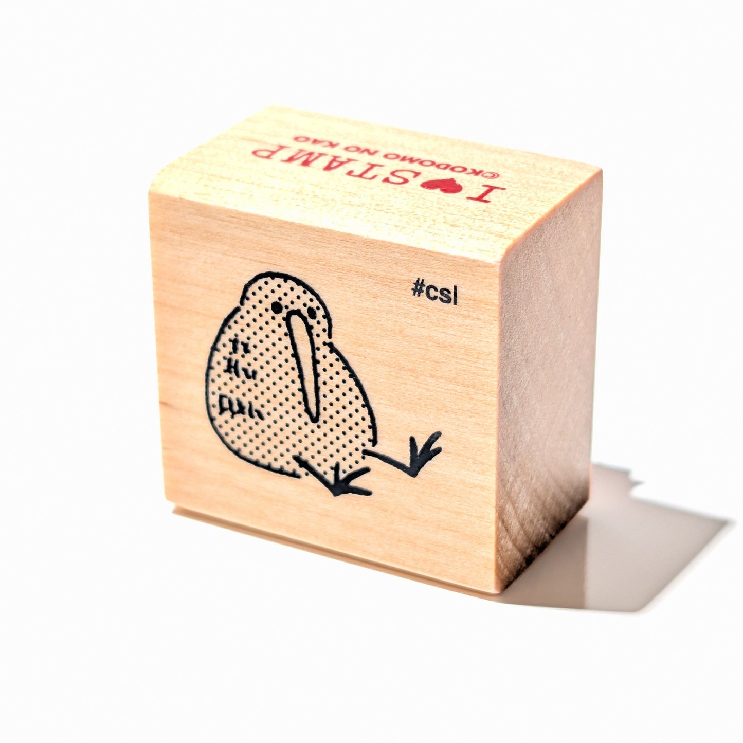 Wooden stamp block with a bird design on a white background