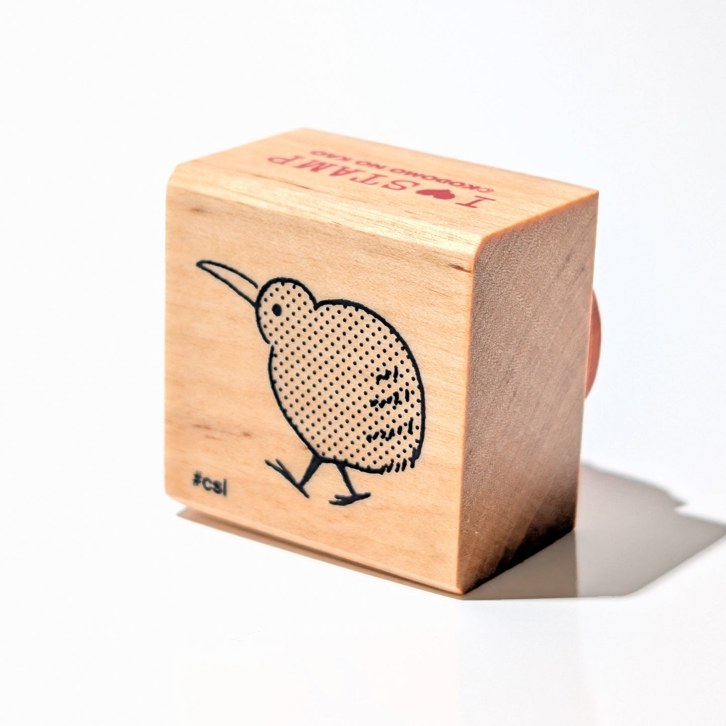 Wooden block with a kiwi bird design on a white background