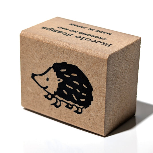 Brown cardboard block with a hedgehog design and text on a white background