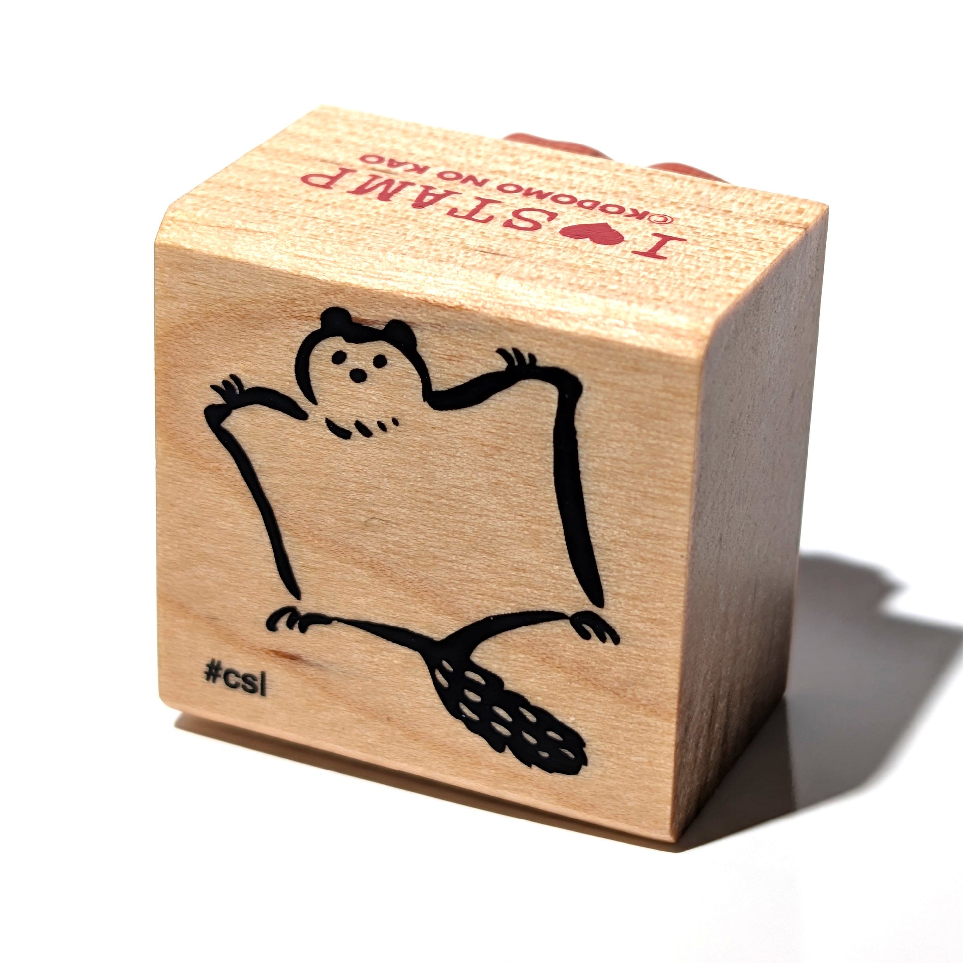 Wooden stamp with a cartoon character and text on a white background