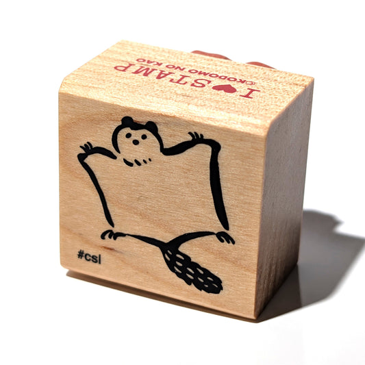 Wooden stamp with a cartoon character and text on a white background