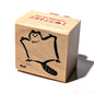Wooden stamp with a cartoon character and text on a white background