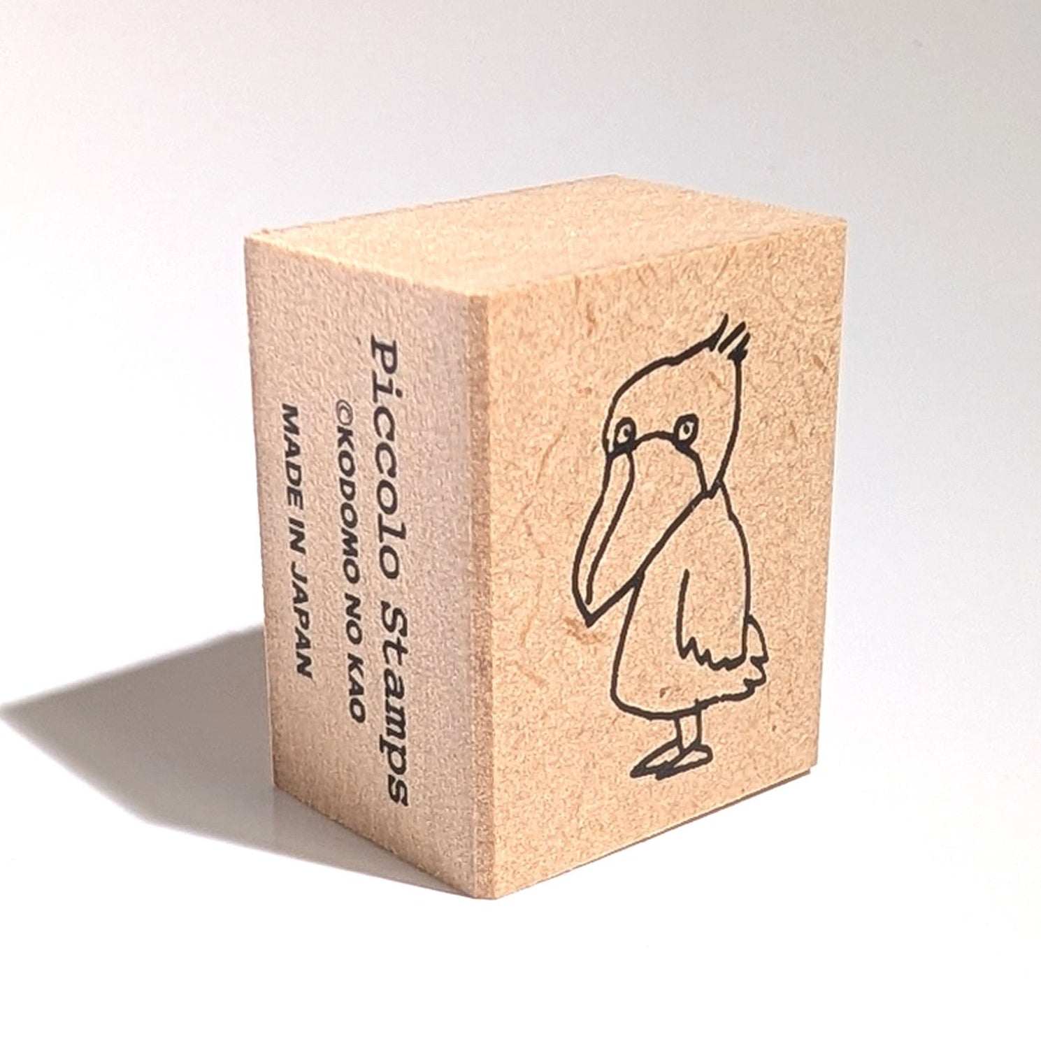 Wooden stamp block with a bird illustration on a white background