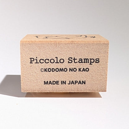 Piccolo Stamps packaging on a gray background