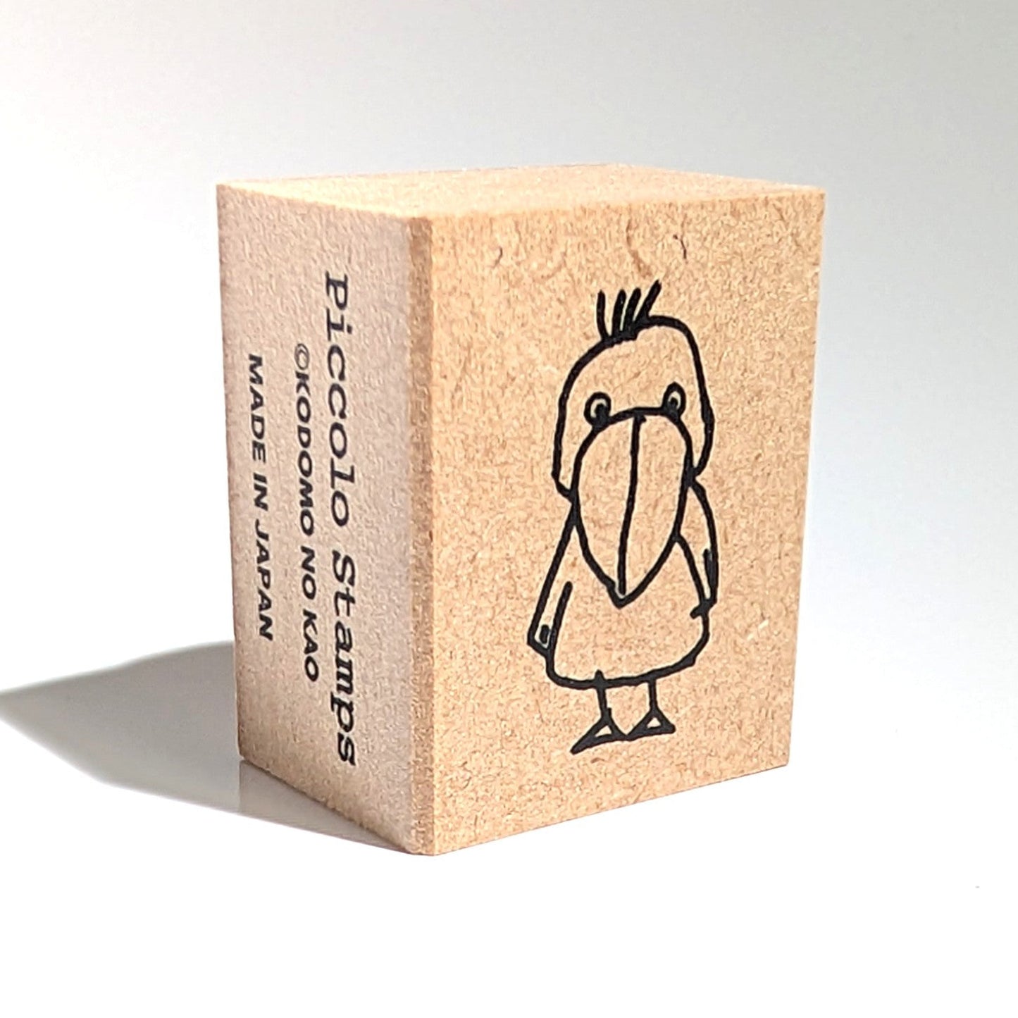 Wooden stamp block with a cartoon branding on a white background.