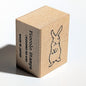 Wooden stamp block with a rabbit design and 'Piccolo Stamps' branding on a white background