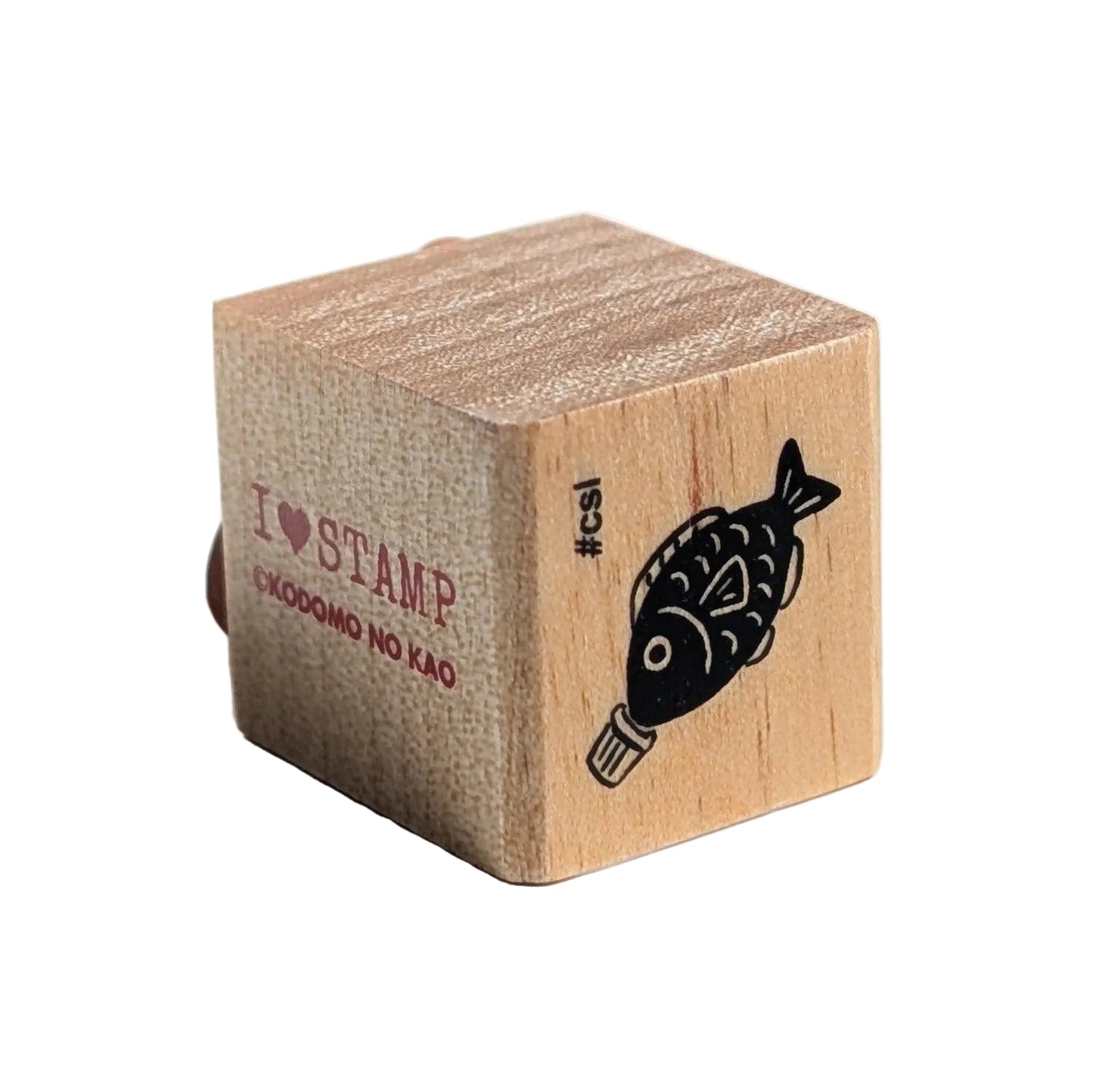 Wooden stamp block with a fish design and text on a white background