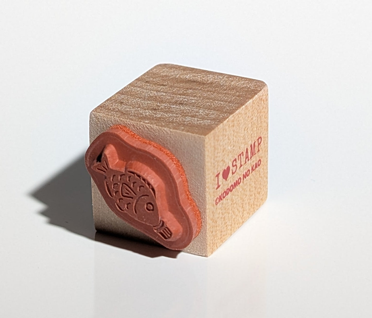 Wooden stamp with red ink pad on a white background