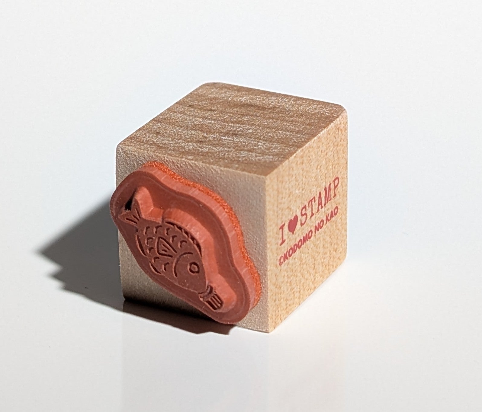 Wooden stamp with red ink pad on a white background