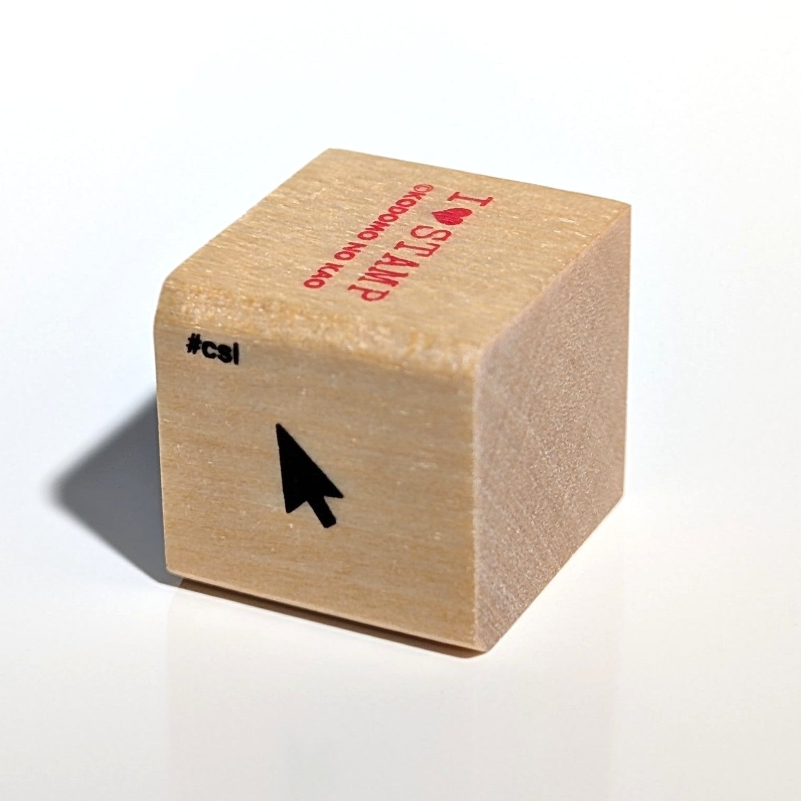 Wooden stamp with text and a black arrow on a white background