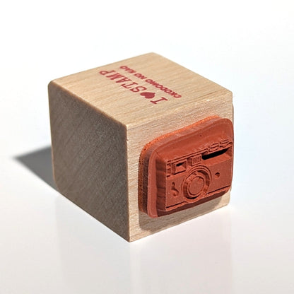 Wooden stamp with a camera design on a white background