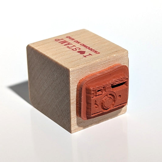 Wooden stamp with a camera design on a white background