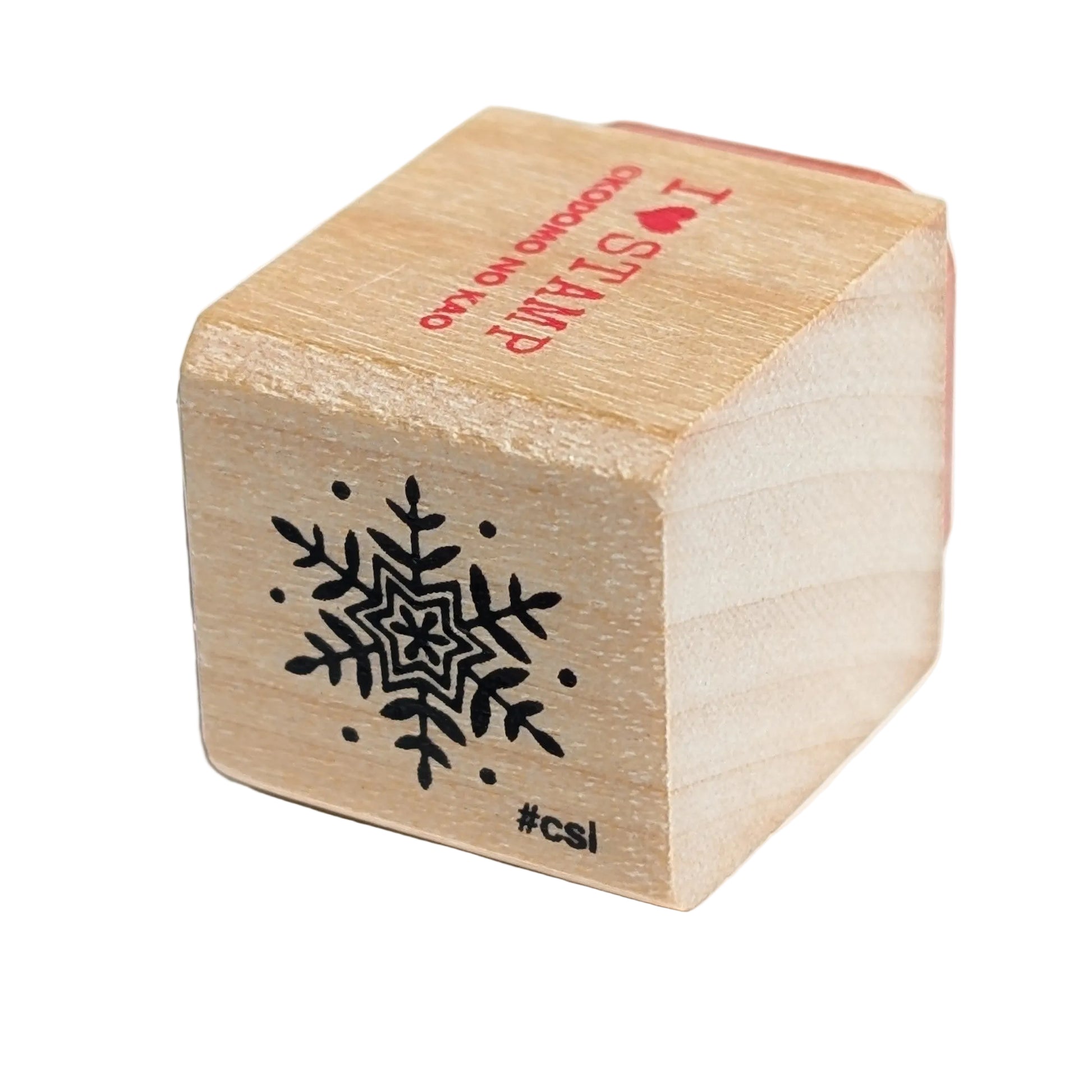 Wooden stamp with snowflake design and text on a white background