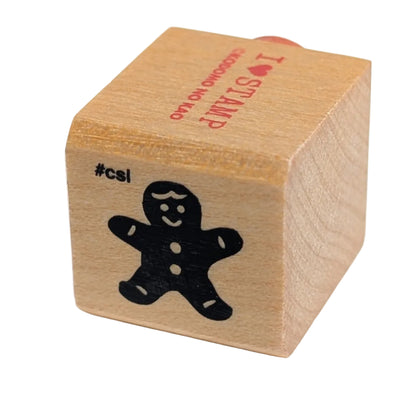 Wooden stamp with a black cutout of a gingerbread man on a white background