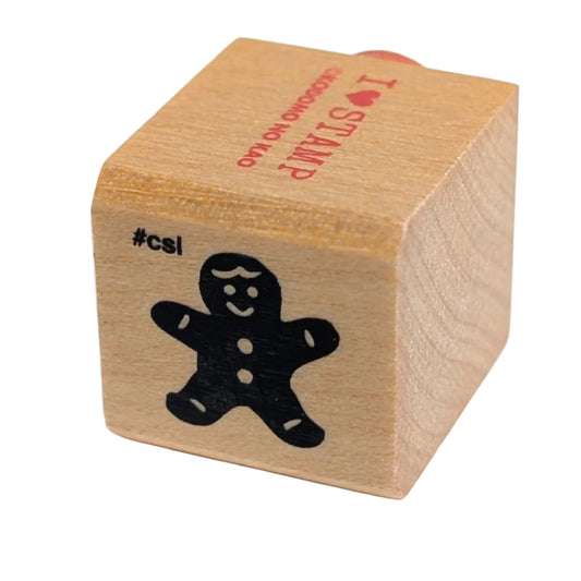 Wooden stamp with a black cutout of a gingerbread man on a white background