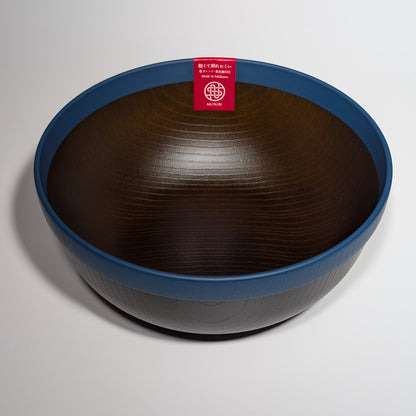 Wooden bowl with a blue rim and a red label on a light gray background