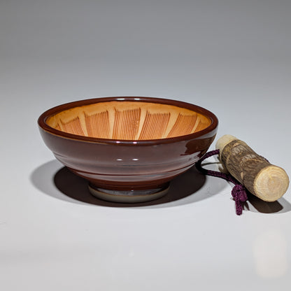 Ceramic bowl with wooden handle on a gray background