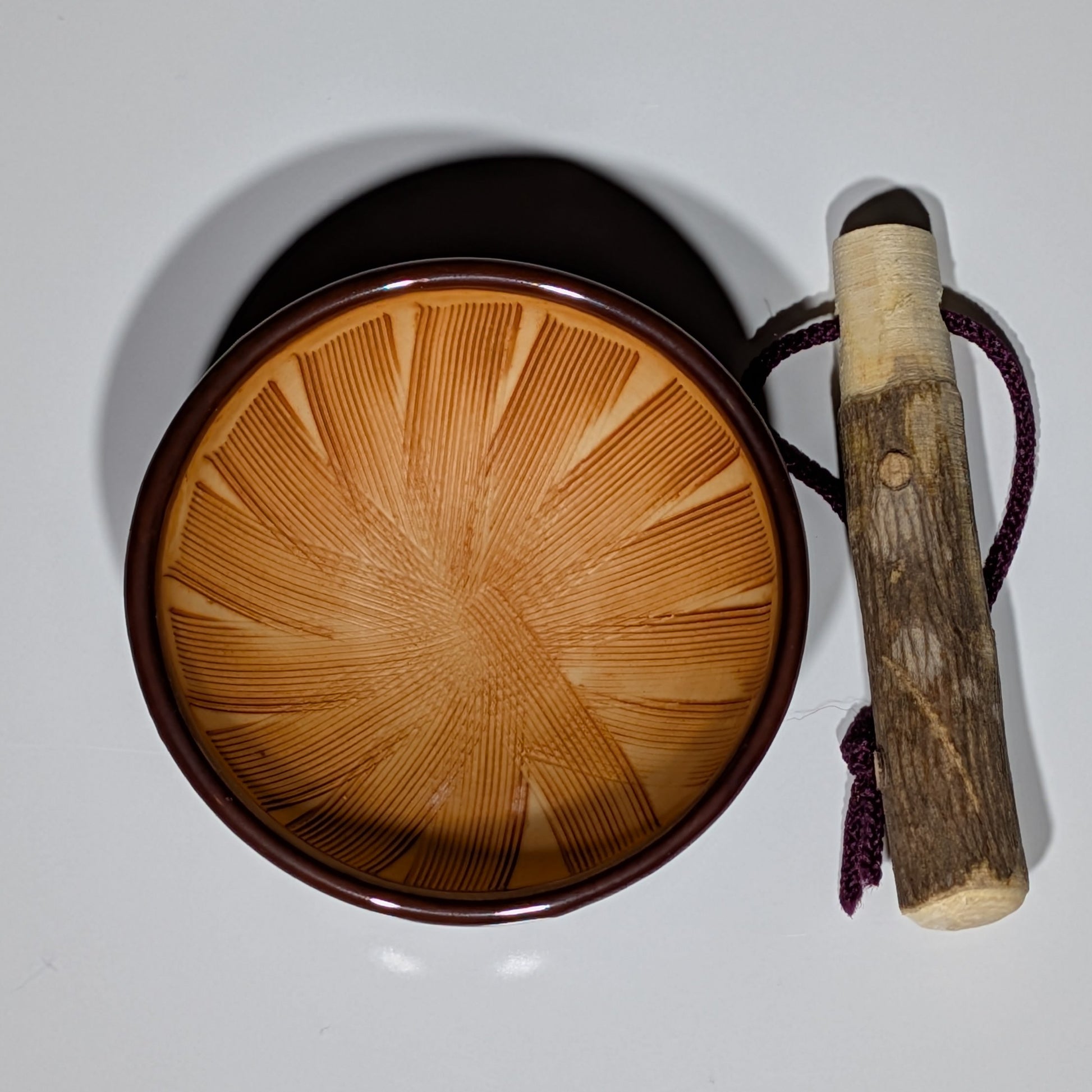 Wooden singing bowl with a wooden handle on a white background