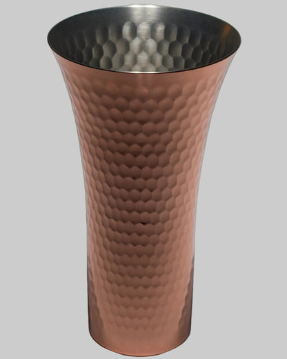 Hammered copper beer tumbler on a gray background