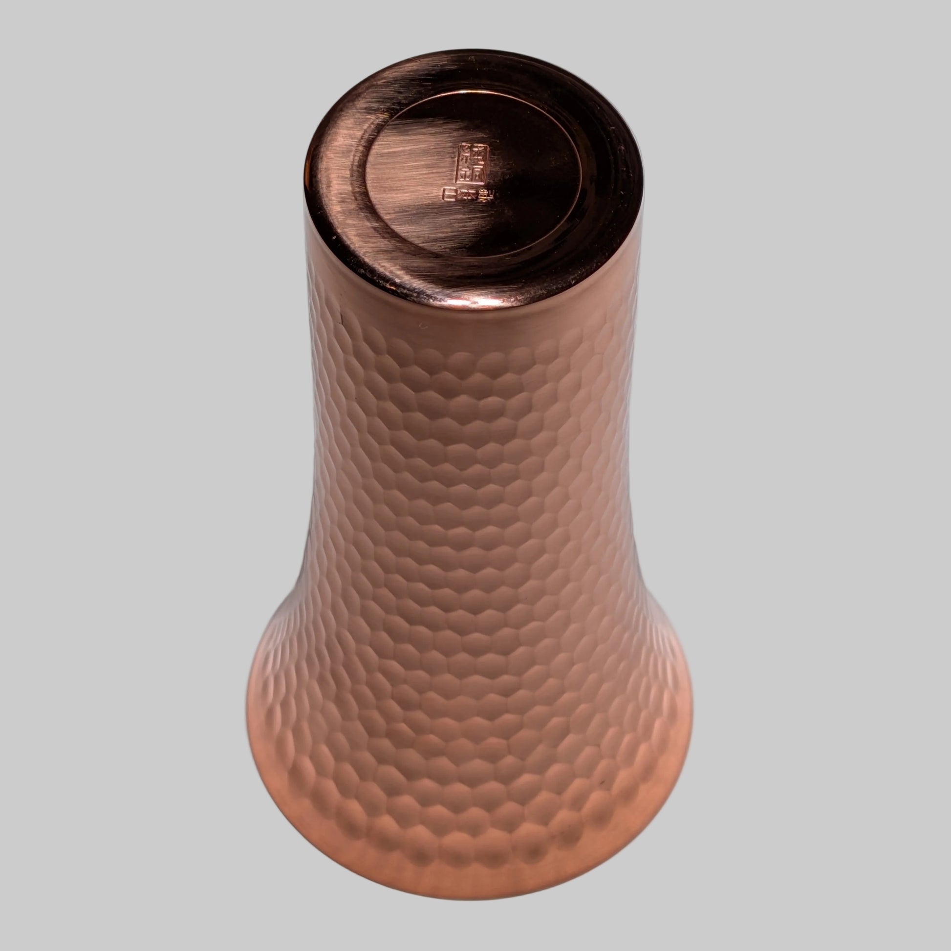 Copper textured bottle on a gray background