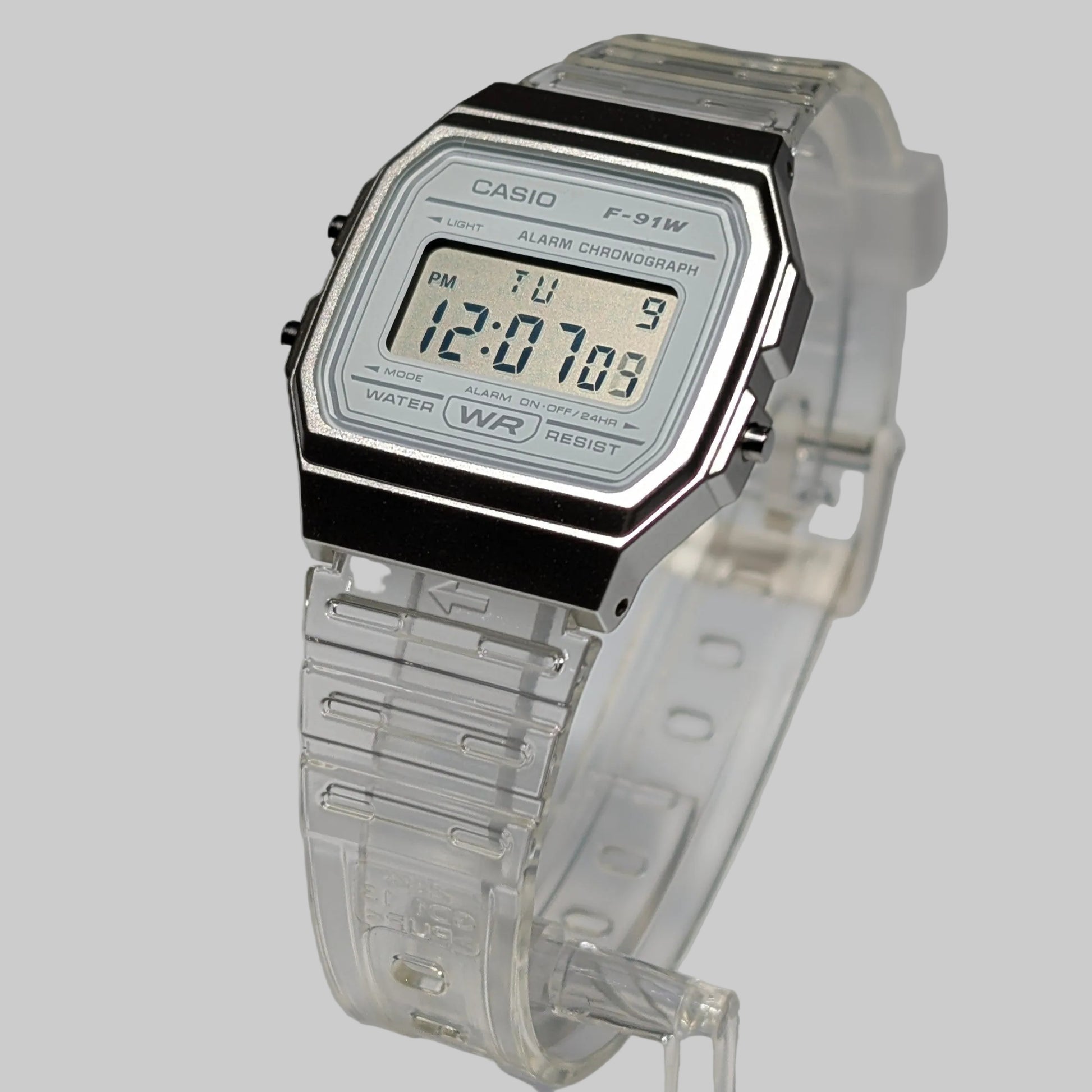 Digital watch with clear strap and Casio branding on a gray background
